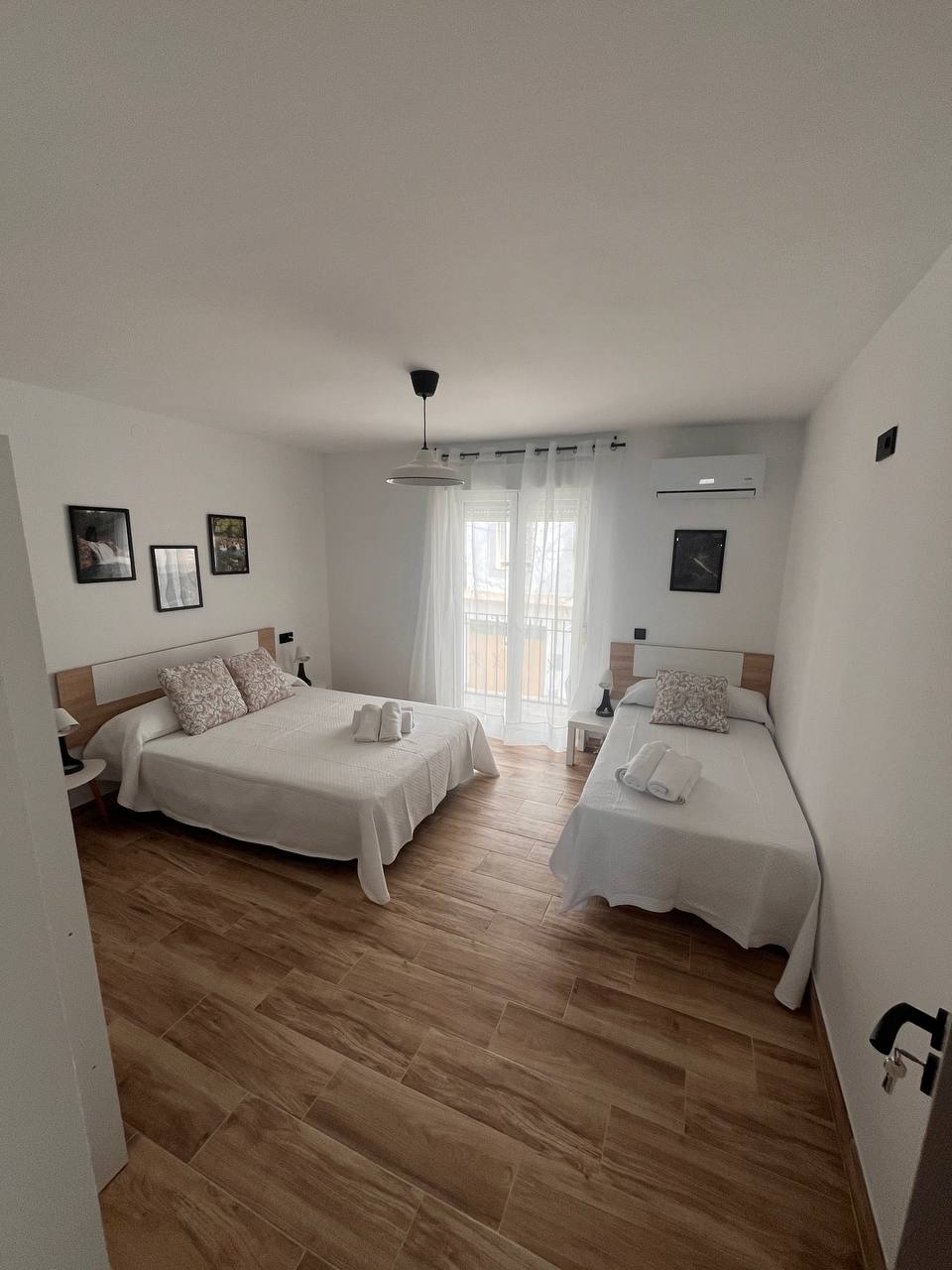 Dormitorio principal con cama de matrimonio, aire acondicionado y balcón